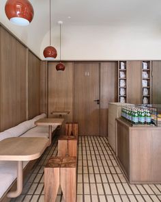 the interior of a restaurant with wooden tables and benches