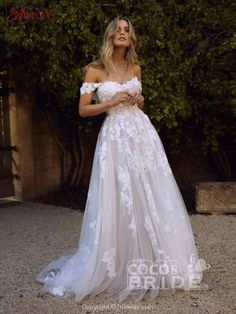 a woman in a white wedding dress posing for the camera with her hand on her hip