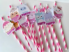 pink and white paper straws with cartoon characters on them are sitting next to each other