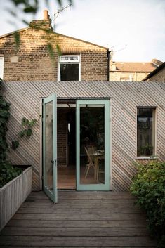 an outdoor room with sliding glass doors on the outside and wooden decking around it