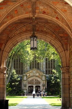 an archway leading to a building with people walking in it