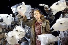 a woman standing in front of several white masks with wolf heads on it's faces