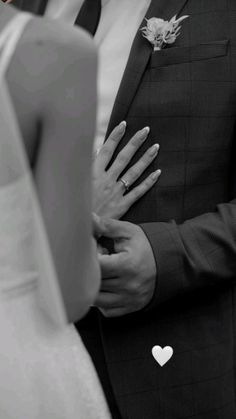 the bride and groom are holding their hands close together as they stand next to each other