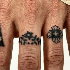 two fingers with tattoos on them, one has a clock and the other has snowflakes