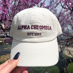 a person holding up a white hat with the words, alpa chi omega est Sorority Apparel Hats, Corduroy Hats, Omega Alpha, Embroidered Corduroy, Alpha Sigma Tau, Corduroy Hat, Delta Phi Epsilon, Alpha Phi Alpha, Big Little Gifts