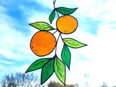 a stained glass sun catcher with two oranges on it