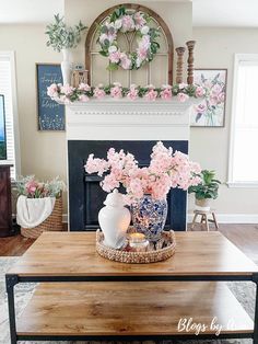 a coffee table with flowers on it in front of a fire place and a fireplace