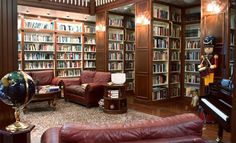 a living room filled with lots of brown furniture and bookshelves full of books