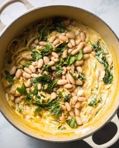 beans and spinach are mixed together in a pot