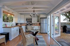 an open kitchen and dining room with sliding glass doors that lead to the deck area