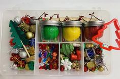 jars filled with different types of ornaments and decorations in a plastic container on top of a white table