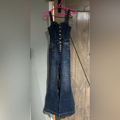 Denim Jumpsuit. Overall Style Adjustable Shoulder Straps. Fully Functional Buttons And A Flare Leg With Front And Back Pockets Denim Button-up Overalls With Buttons, Button-up Denim Overalls With Buttons, Buttoned Denim Overalls, Button-up Denim Overalls, Dark Wash Button-up Jumpsuits And Rompers, Fitted Medium Wash Denim Jumpsuit With Button Closure, Fitted Denim Blue Jumpsuit With Button Closure, Fitted Denim Button-up Jumpsuit, Denim Jumpsuits And Rompers With Buttons In Medium Wash