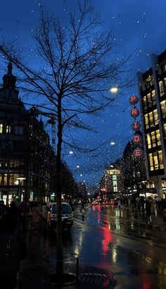 a city street at night with people walking on the sidewalk