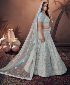 Step into the enchanting world of sky blue elegance with our "Azure Sky" bridal ghaghara. Made from premium georgette and net fabrics with handwork detailing, this outfit features bridal latkans, a 3.5-meter lehenga flair, and Zarkan embellishments throughout the lehenga and blouse. Elevate your wedding look with this graceful attire that's perfect for various wedding functions. Product Details: Lehenga Choli Color: Azure Dupatta Color: Light Blue Lehenga : Lino Silk & Nylon Satin Choli: Kumkum