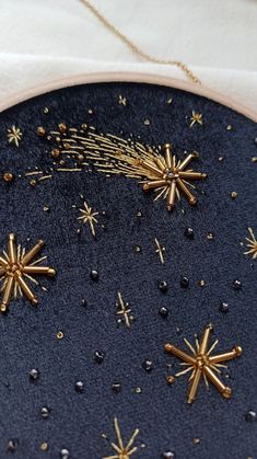 a black surface with gold stars and sparkles in the center, on top of a white cloth