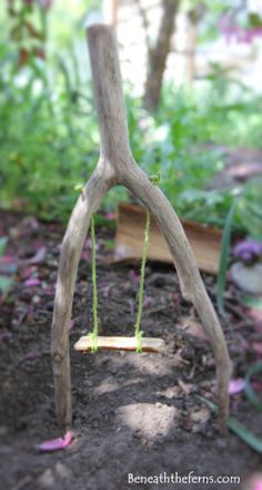 a wooden swing made out of branches in the dirt with purple flowers around it and text overlay that reads, how to make a tree swing