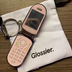 a pink cell phone sitting on top of a white bag next to a pair of glasses