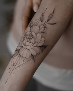 a woman's arm with a flower tattoo on it