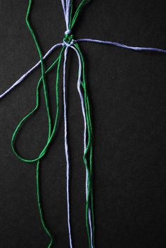 the string has been tied together to make a cross shape with green, white and blue yarn