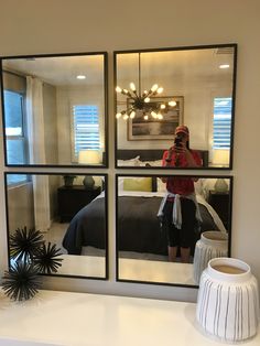 a woman taking a selfie in front of a bedroom window with the lights on