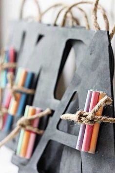 several colored candles are tied up to a black bag with twine on the handles