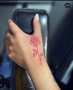 a woman's hand with a rose tattoo on it