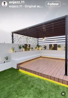 an outdoor area with grass and lights on the ground, under a pergolated roof