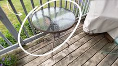 an outdoor table on a wooden deck next to a chair