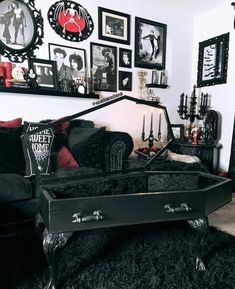 a living room filled with black furniture and pictures on the wall above it's coffee table