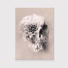 a black and white photo of a skull with flowers on it's back side