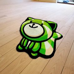 a rug with a green and white teddy bear on it