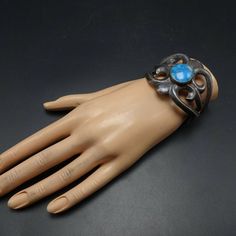 "VINTAGE NAVAJO BRACELET DESCRIPTION: Heavy gauge cast sterling silver with dark patina and a gorgeous specimen of high blue Morenci turquoise. This bracelet will be a cherished addition to your collection of fine vintage Native American jewelry. MEASUREMENTS: Interior of the cuff measures 5 1/4\" with an additional 1 1/8\" non-adjustable gap. Total circumference: 6 3/8\" Measures 2 3/8\" straight across the widest part (from wrist bone to wrist bone) Bracelet face measures 2\" wide (the face of Modernist Turquoise Jewelry Gift, Adjustable Blue Oxidized Finish Jewelry, Patina Bracelet Jewelry Gift, Blue Stamped Bracelet As Gift, Silver Patina Cuff Bracelet As A Gift, Silver Cuff Bracelet With Patina As Gift, Blue Patina Bracelet Jewelry, Unique Hand Cast Blue Jewelry, Blue Patina Bracelet