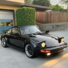 a black sports car parked in front of a house