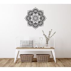 a white bench sitting in front of a wall with a black and white design on it