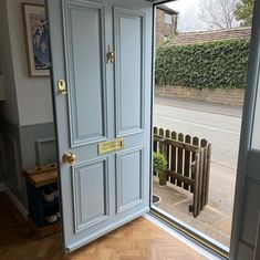 an open door leading to a balcony with wooden flooring and white painted doors on either side