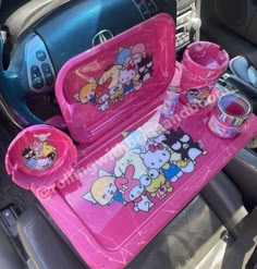 pink hello kitty car seat trays with cups and saucers in the backseat of a car