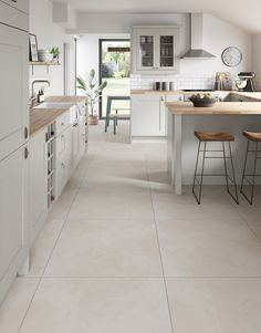 a kitchen with white cabinets and counter tops