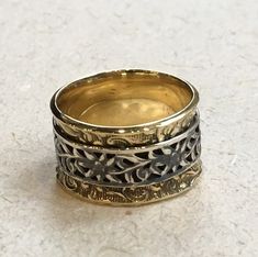 A way to you This is a pretty floral spinner ring. The main band is vine filigree design made from brass. On top a floral sterling silver spinner ring. R2368 © 2011-2016 Artisanimpact Inc. All rights reserved. Construction & Dimensions: Brass, Sterling silver. Approximate width: 14mm (0.55in). Please note that depending on the acidity of your skin, brass jewelry can tarnish your skin quicker than others We can make any size, including quarter sizes. For this wider band, we suggest adding .5 Bohemian Rings With Engraved Wide Band, Handmade Adjustable Bohemian Filigree Ring, Bohemian Sterling Silver Filigree Ring, Bohemian Silver Brass Rings, Boho Wedding Bands, Silver And Gold Spinner Ring, Simple Silver Ring, Wide Silver Band, Silver Rings Simple