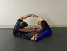 two men are sitting on the floor doing exercises