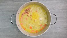 a pot filled with soup sitting on top of a wooden table