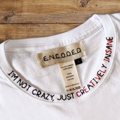 "White tee shirt with hand-embroidered funny phrase \"I'm not crazy, just creatively insane\".  MATERIAL 100% cotton. SIZES You can finde size guide on the photo area. Please check the size before the buying. GARMENT CARE Delicate machine wash at 30 degrees. DELIVERY ESTIMATES Next 1-2 working days dispatch. SPAIN customers - estimated delivery 3-5 working days. EUROPEAN customers - estimated delivery 5-10 working days. INTERNATIONAL customers - Estimated delivery 14-21 working days. Choose your mood!" Unisex Christmas Gifts, White Tee Shirt, White Short Sleeve Shirt, Slogan Shirts, Embroidery Tshirt, White Tee Shirts, Funny Slogans, Painted Denim, Shirt Embroidery