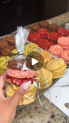 a person is holding up a plastic bag with cookies in front of them on the counter