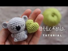 a tiny crocheted koala bear holding a green apple in its hand with the words little koala on it