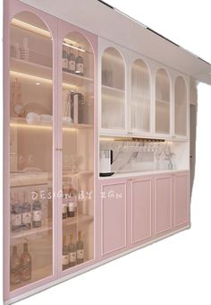 a kitchen with pink cabinets and white counter tops, along with glass doors that lead into the pantry