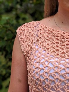 a close up of a woman wearing a pink top