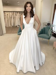 a woman standing in front of a white dress