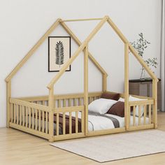 a wooden bed with a house shaped frame on top of it in a white room