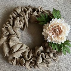 a wreath made out of burlocks and fabric with a flower in the middle