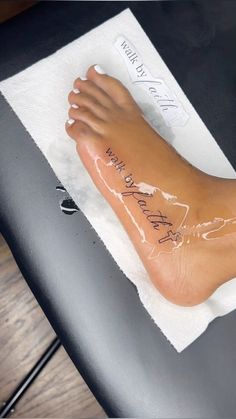 a foot with writing on it sitting on top of a towel