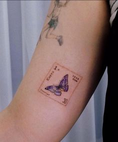 a woman's arm with a purple butterfly tattoo on the left side of her arm